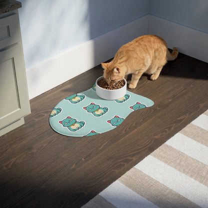 A cat eating from a bowl on the fish-shaped Catch of the Day feeding mat on a kitchen floor.