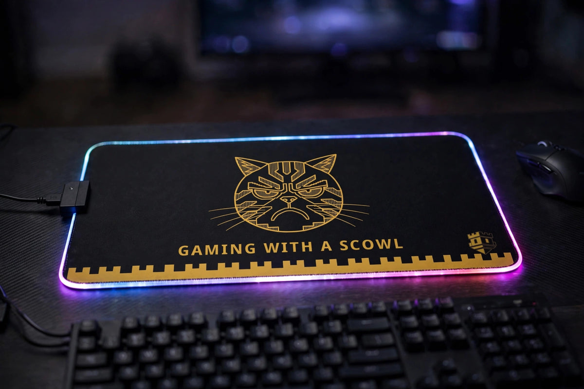 Gaming with a Scowl LED mouse pad lit up at a gaming desk — RGB LED edge glowing