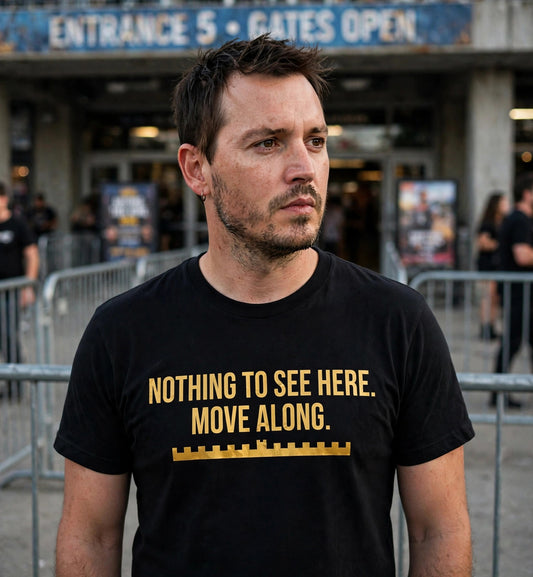 Man wearing the black Nothing To See Here Move Along t-shirt at a venue entrance