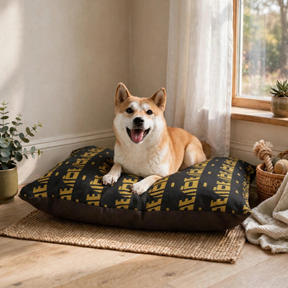 A small dog resting on the black and gold Perimeter Secured pet bed by a window at home.
