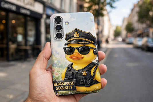Rubber Duck Security premium tough phone case on a phone held in a hand on a street, showing the security duck design on the case back